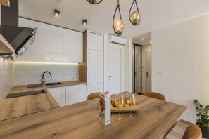 Deluxe Studio | Private kitchen | Electric kettle, highchair, dining tables