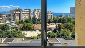 A view of a cityscape with multiple buildings, including a prominent high-rise and several mid-rise structures. - Zozo, Modern Two-Bedroom Suite (Split)