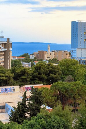 A coastal cityscape with a mix of residential and commercial buildings, including a prominent tower and a building with graffiti. - Zozo, Modern Two-Bedroom Suite (Split)