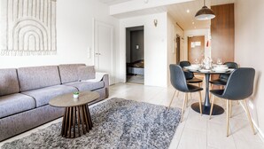 A modern living room with a grey sofa, a round wooden coffee table, and a grey shaggy rug. - Modern 1BR Apartment next to Ski Slopes (Sirkka)