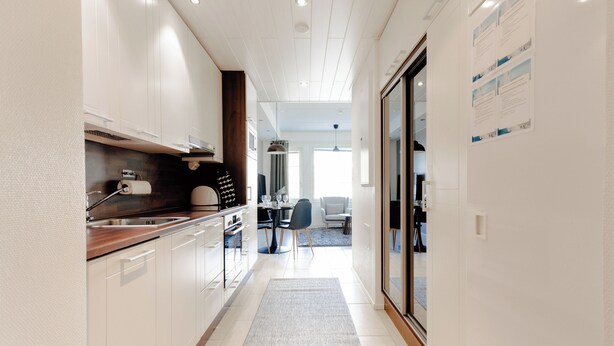 A modern kitchen with white cabinets, a wooden countertop, and a built-in oven. - Modern 1BR Apartment next to Ski Slopes (Sirkka)