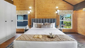 A bedroom with a large bed, wooden ceiling, and a window with a view of greenery. - ELIVAAS Esh Birch  (Palampur)