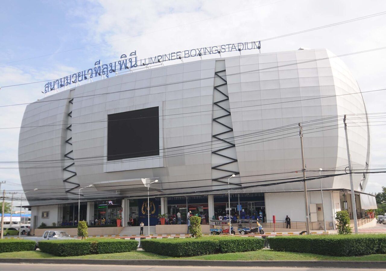 A modern, large stadium with a prominent entrance and a large screen.