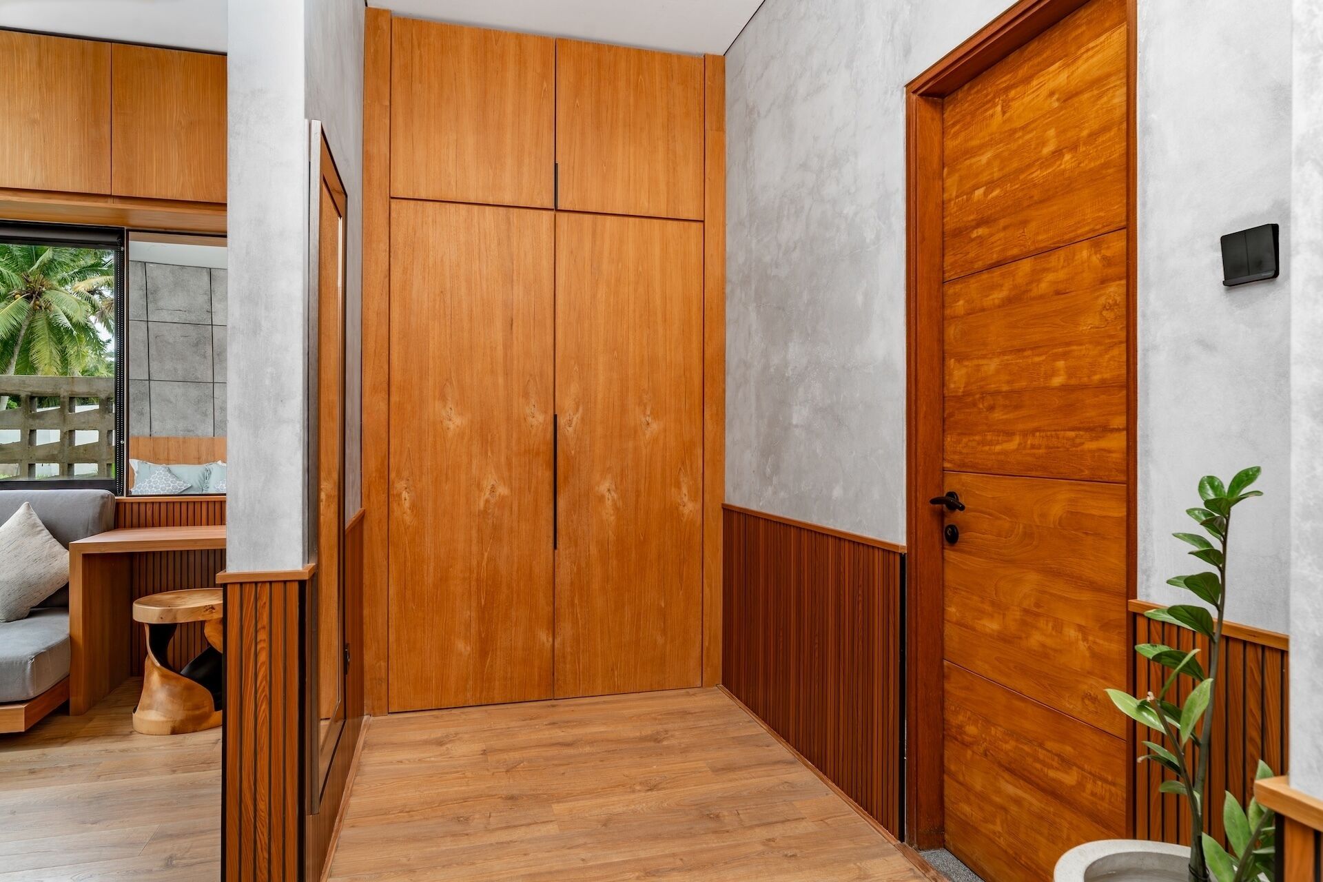A hallway with wooden doors, a bench, and a small table.