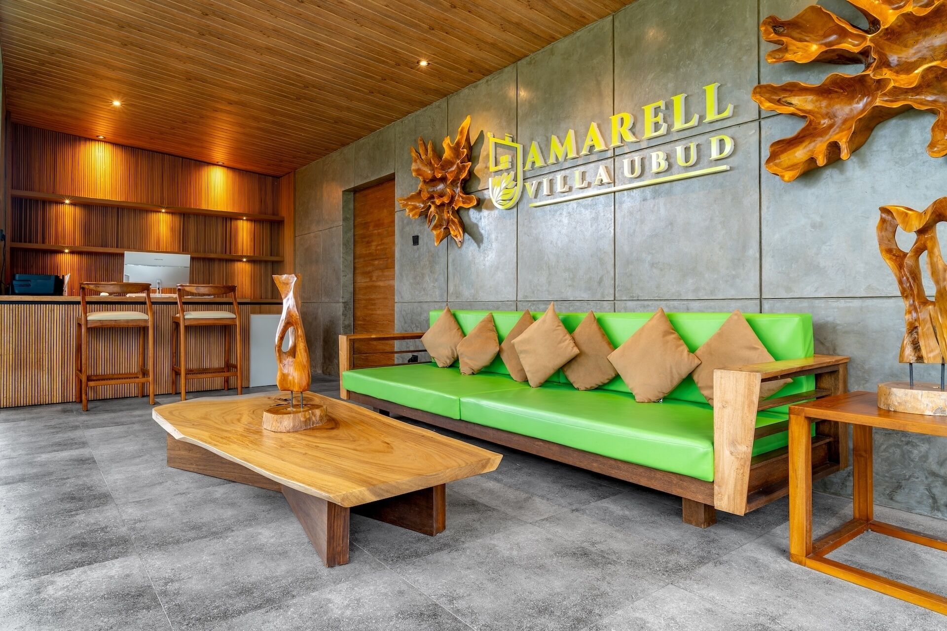 Een moderne lobby met een groene bank, houten stoelen, een houten salontafel en een receptiebalie.
