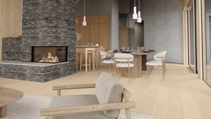 Ein großzügiger Wohnbereich mit Kamin aus Stein, Holzboden und einem Essbereich mit modernen Möbeln.