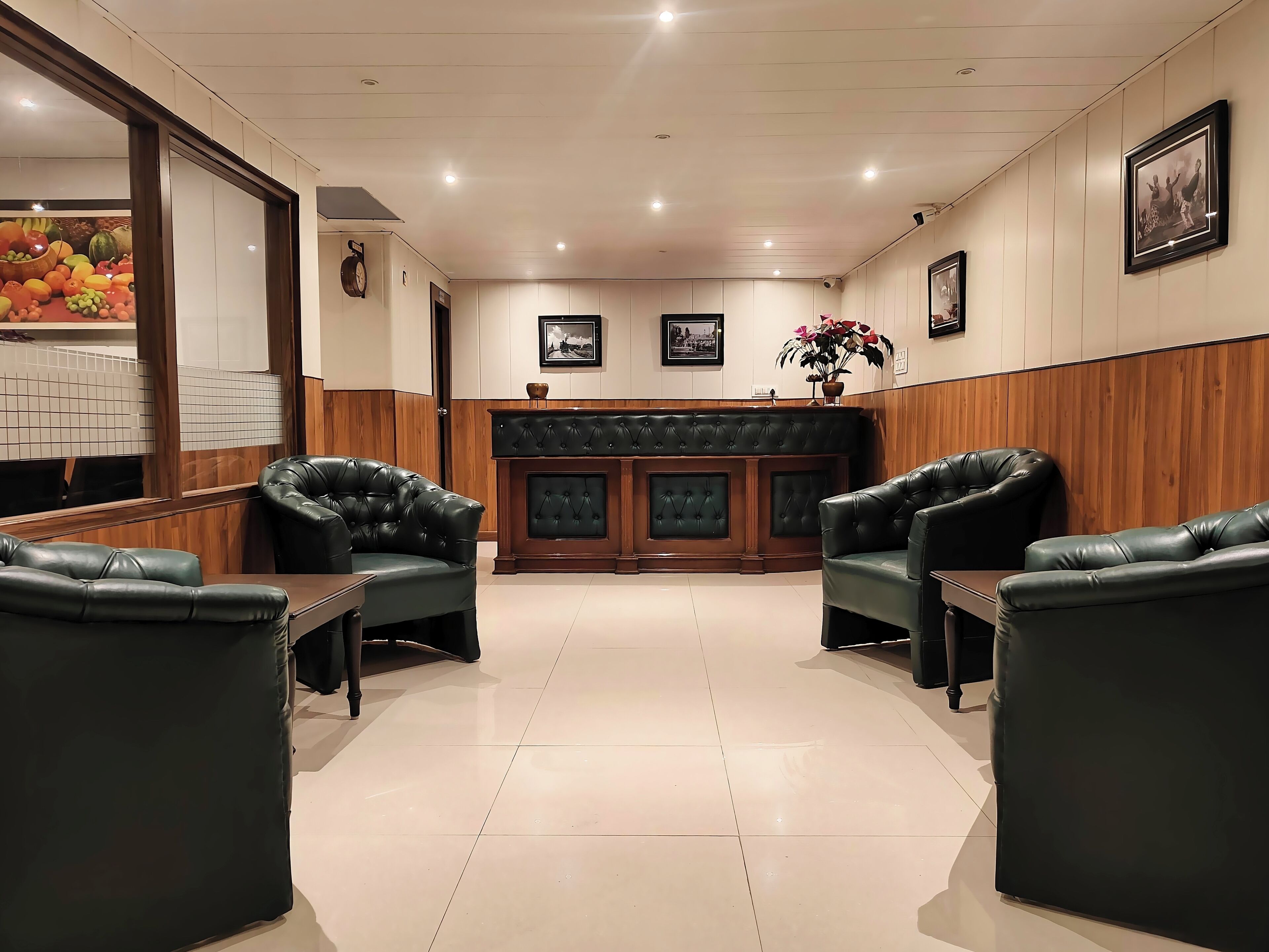 A lobby with leather armchairs, a wooden reception desk, and framed pictures on the walls.