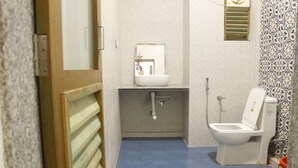 Un baño pequeño con inodoro, lavamanos y ducha.