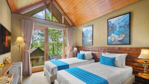 Una habitación de hotel con dos camas, un ventanal grande, un cuadro y techo de madera.