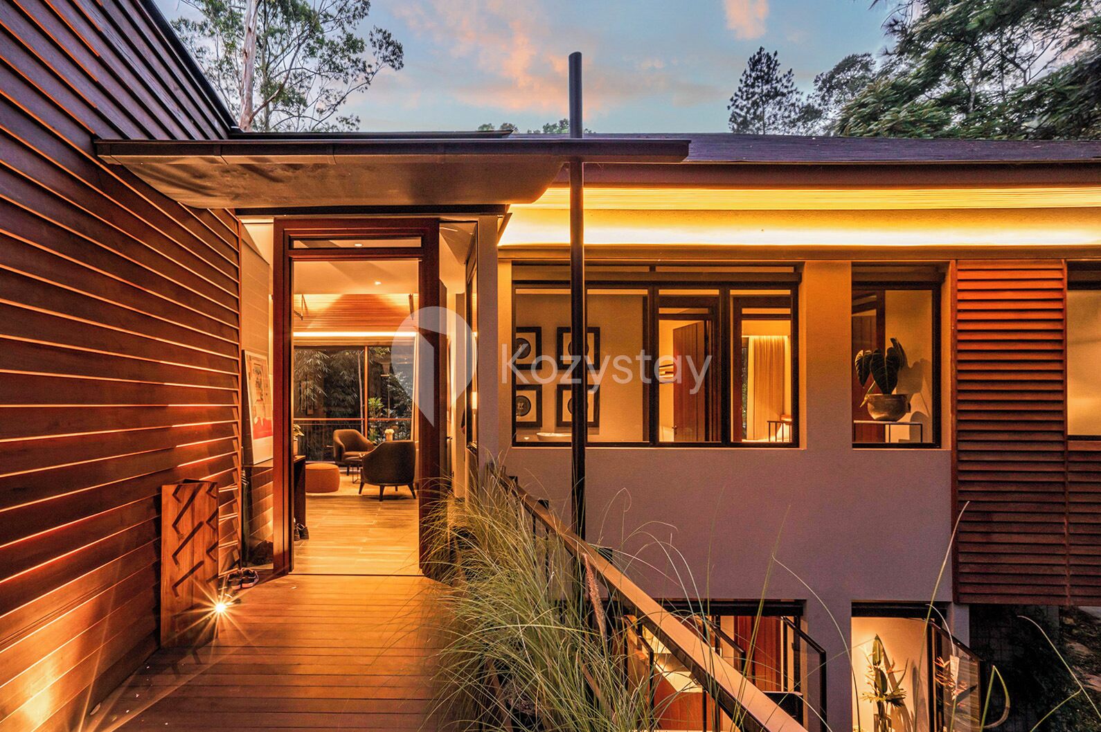 A modern house with a wooden deck, a staircase, and a view of the interior.