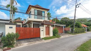 A two-story house with a red gate, a small porch, and a sign that reads "Parque pal". - PoolVilla Jacuzzi & Mountain View V232 (Rawai)