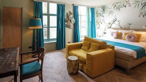 A room with a bed, a sofa, a chair, a table, and a lamp. - Hotel 1635 (Haarlem)