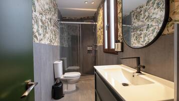 Un baño moderno con ducha, inodoro y lavamanos.