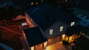 A residential house with a driveway, a garage, and a small garden area with string lights.