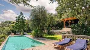 A rectangular swimming pool with lounge chairs and a pergola in a landscaped garden. - Villa in Sète on Mont St Clair with heated pool (Sete)