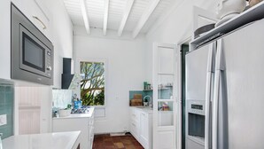 A modern kitchen with white cabinetry, a built-in microwave, and a refrigerator with a water dispenser. - Villa in Sète on Mont St Clair with heated pool (Sete)