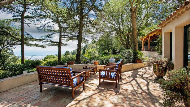 A patio with wooden furniture, potted plants, and a view of the sea. - Villa in Sète on Mont St Clair with heated pool (Sete)