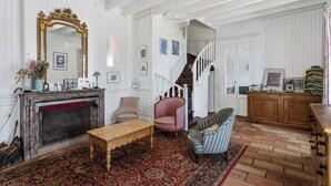 A traditional living room with a fireplace, a staircase, and a dining area. - Villa in Sète on Mont St Clair with heated pool (Sete)