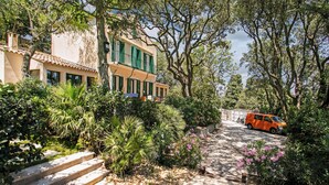 A two-story building with a balcony, surrounded by lush greenery and a stone pathway. - Villa in Sète on Mont St Clair with heated pool (Sete)