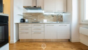 Een moderne keuken met een centraal eiland, een roestvrijstalen afzuigkap en een inbouwvaatwasser.