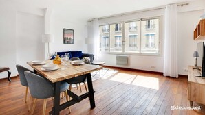 Un espace repas moderne avec une table en bois, des chaises grises et un canapé bleu.