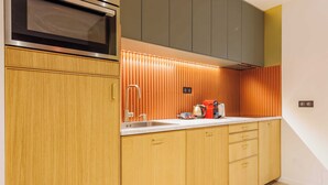 A modern kitchen with wooden cabinets, a stainless steel microwave, and a built-in oven. - Charming Duplex - 2br/6p - Saint Germain (Paris)
