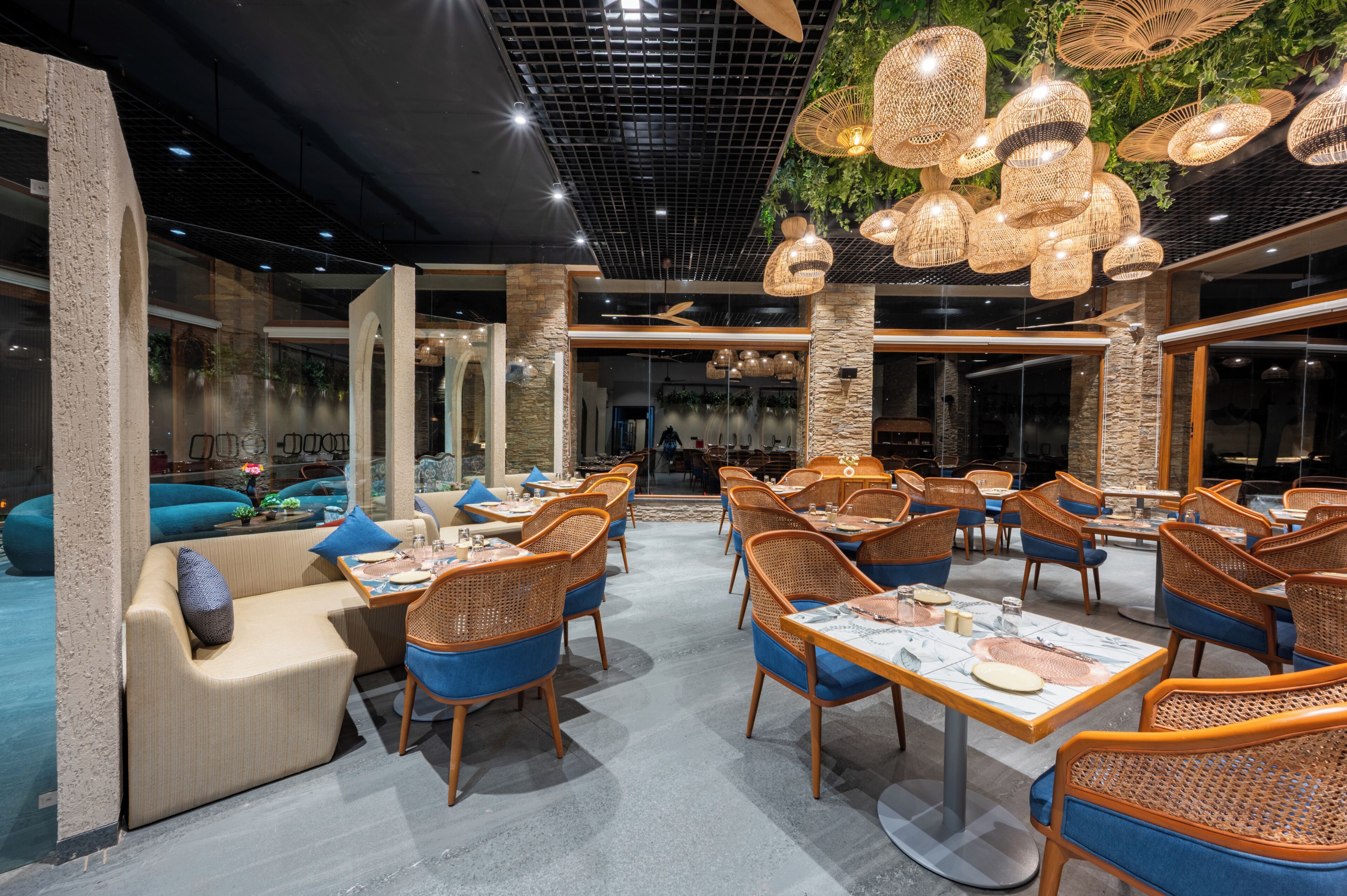 Un restaurant avec de hauts plafonds, des murs en briques apparentes et différents types de sièges, notamment des tables et des chaises.