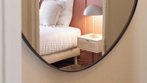 Un dormitorio con cama, lámpara de noche y ventana.