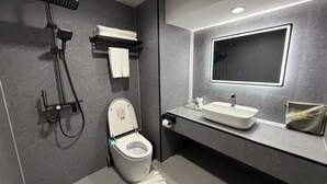 Un baño moderno con inodoro, bidé y cabina de ducha.