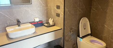 Une salle de bain moderne équipée d’un lavabo, de toilettes et d’une douche.