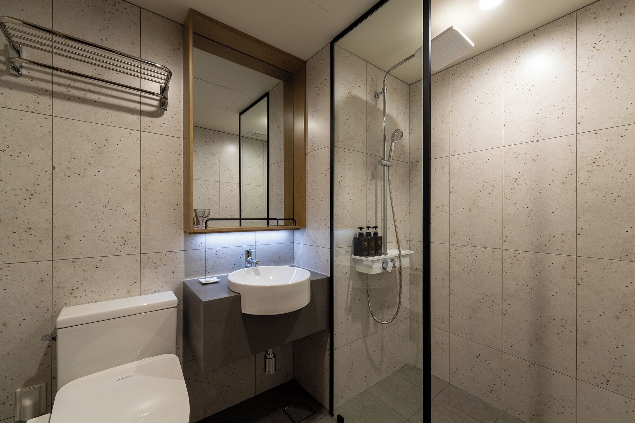 A modern bathroom with a toilet, sink, and shower.