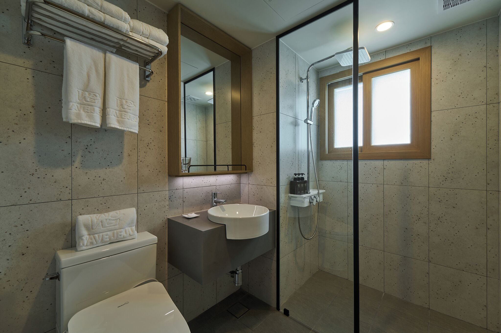 Un bagno moderno con doccia vetrata, lavandino bianco e water.