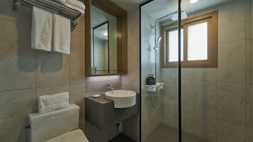 Un bagno moderno con doccia vetrata, lavandino bianco e water.