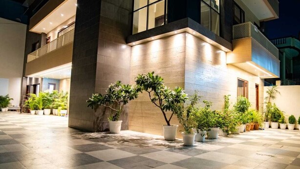 A hotel courtyard with potted plants and a checkered floor. - RAMYA STAYS (Lucknow)