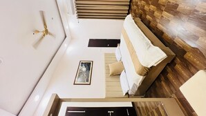 A bedroom with a bed, a ceiling fan, a window, and a wall-mounted air conditioning unit. - RAMYA STAYS (Lucknow)