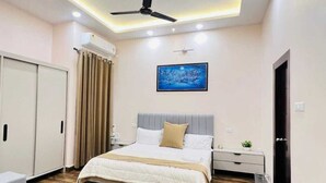 A modern hotel room with a bed, bedside table, and a desk. - RAMYA STAYS (Lucknow)