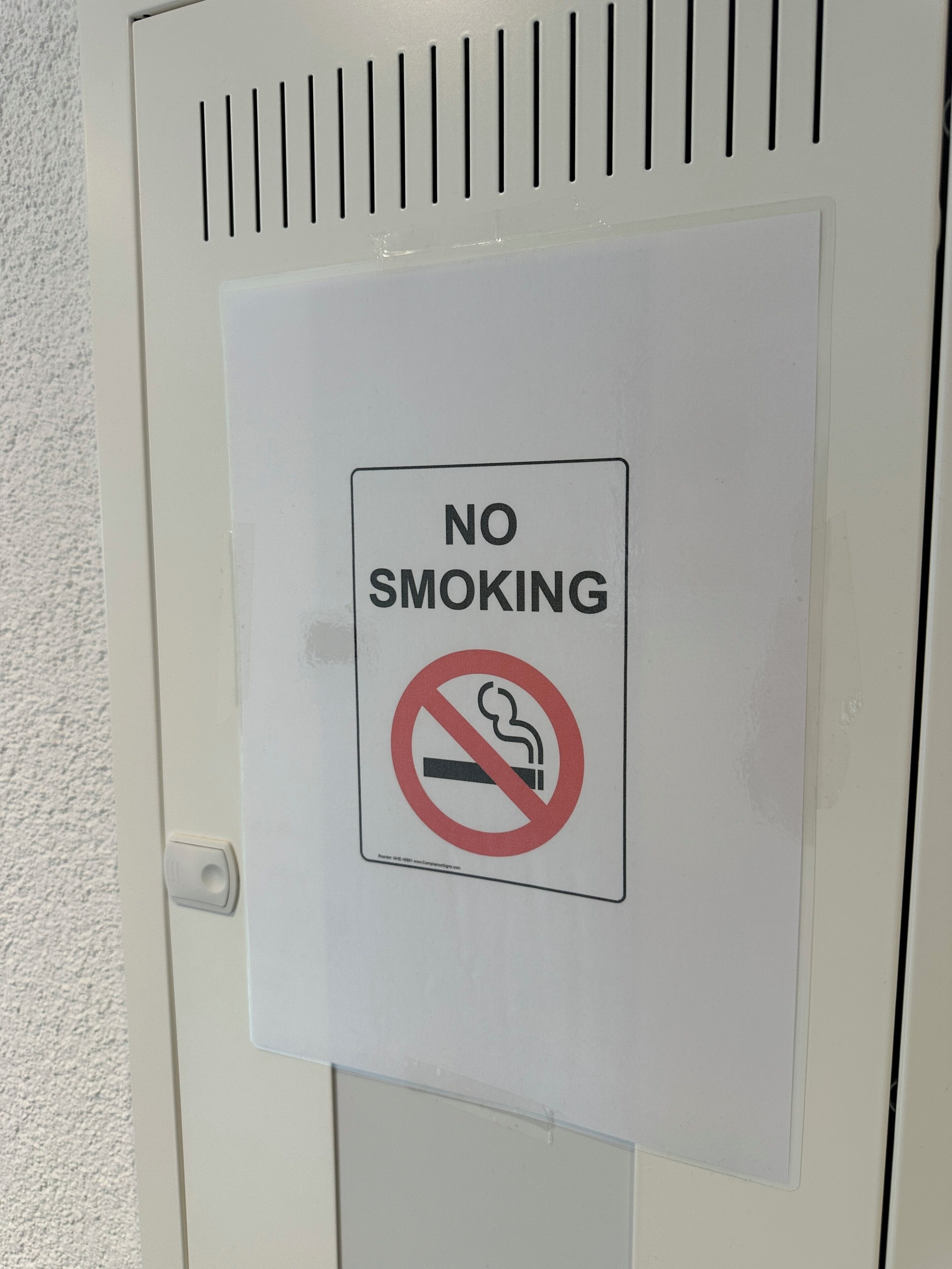 Uma porta com placa de 'NÃO FUMAR'.