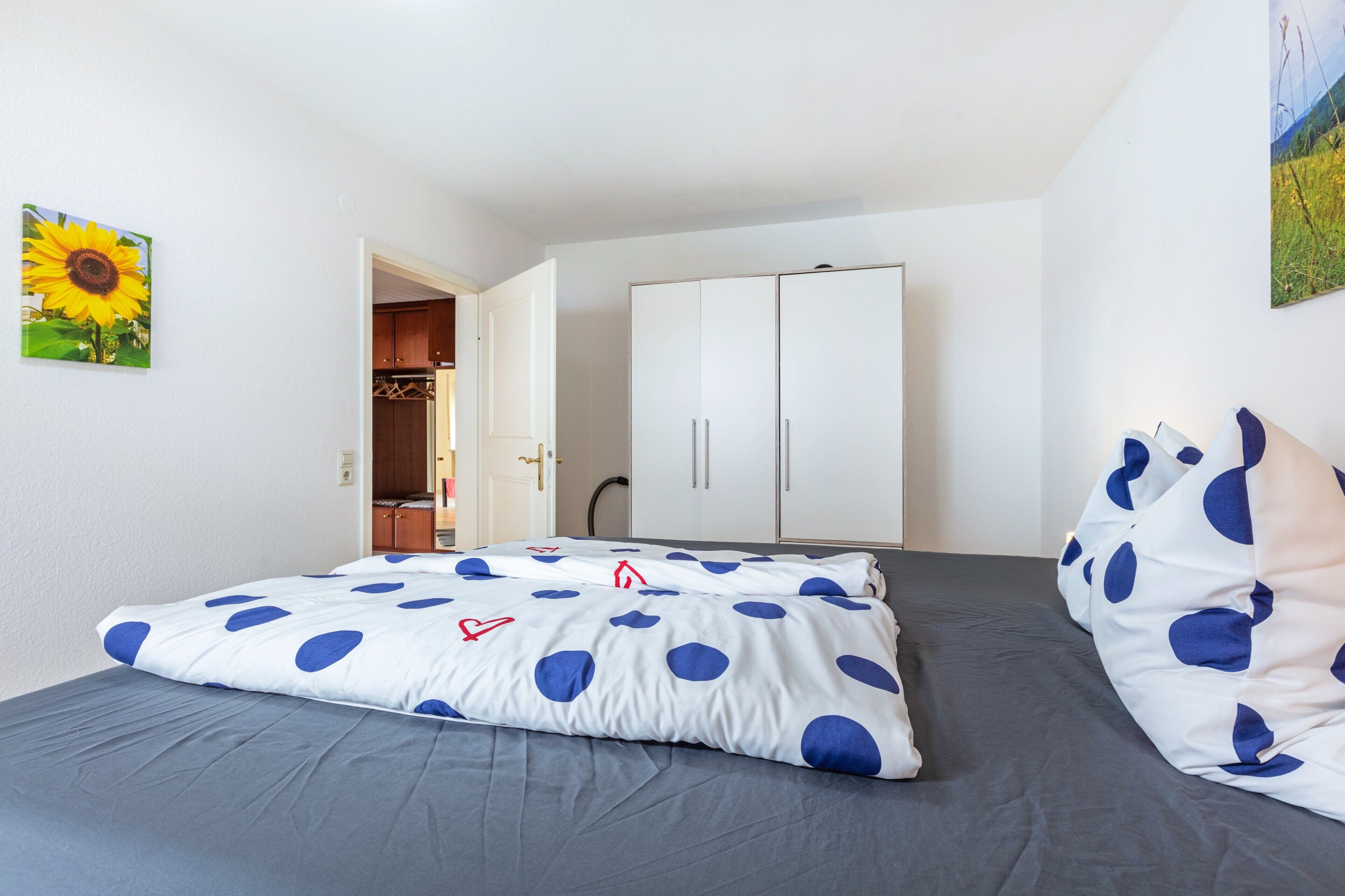 Quarto com uma cama, um guarda-roupa e uma porta que dá para um banheiro.
