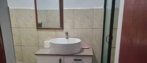 Deluxe suite | Badkamer | Een bad/douchecombinatie, pantoffels, handdoeken, zeep