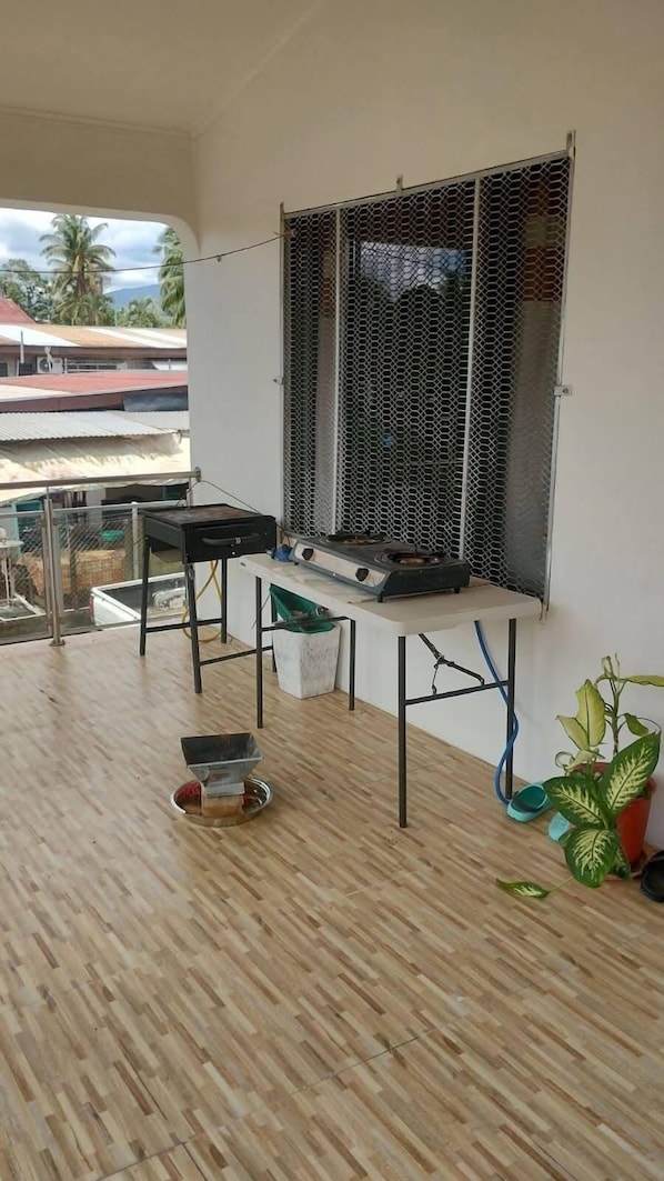 A balcony with a grill, a table, and a chair. - Bulla Villas & Suites (Nadi)
