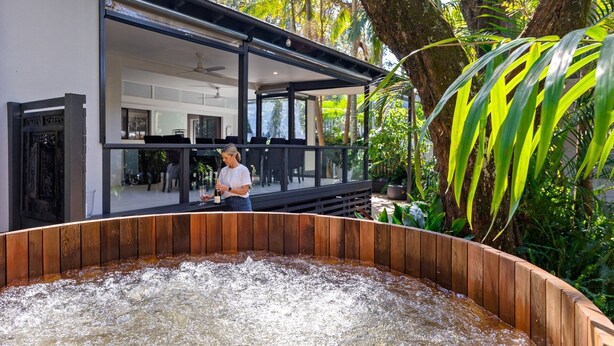Et moderne hus med træterrasse og jacuzzi.
