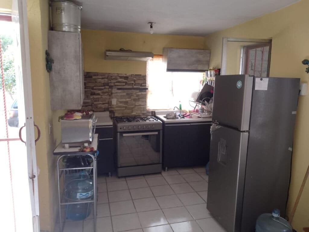 Une cuisine de taille réduite équipée d’une cuisinière à gaz, d’un four et d’un réfrigérateur.