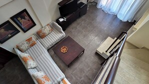 A modern living room with a sofa, a coffee table, and a flat-screen TV. - Evlogia Village by Greek Pride (Nea Skioni)