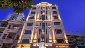 Un hôtel à plusieurs étages, doté d’une architecture classique, et dont l’entrée imposante est agrémentée d’une enseigne lumineuse.