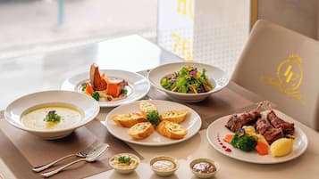 A dining table with various dishes including soup, roasted meat, and vegetables.
