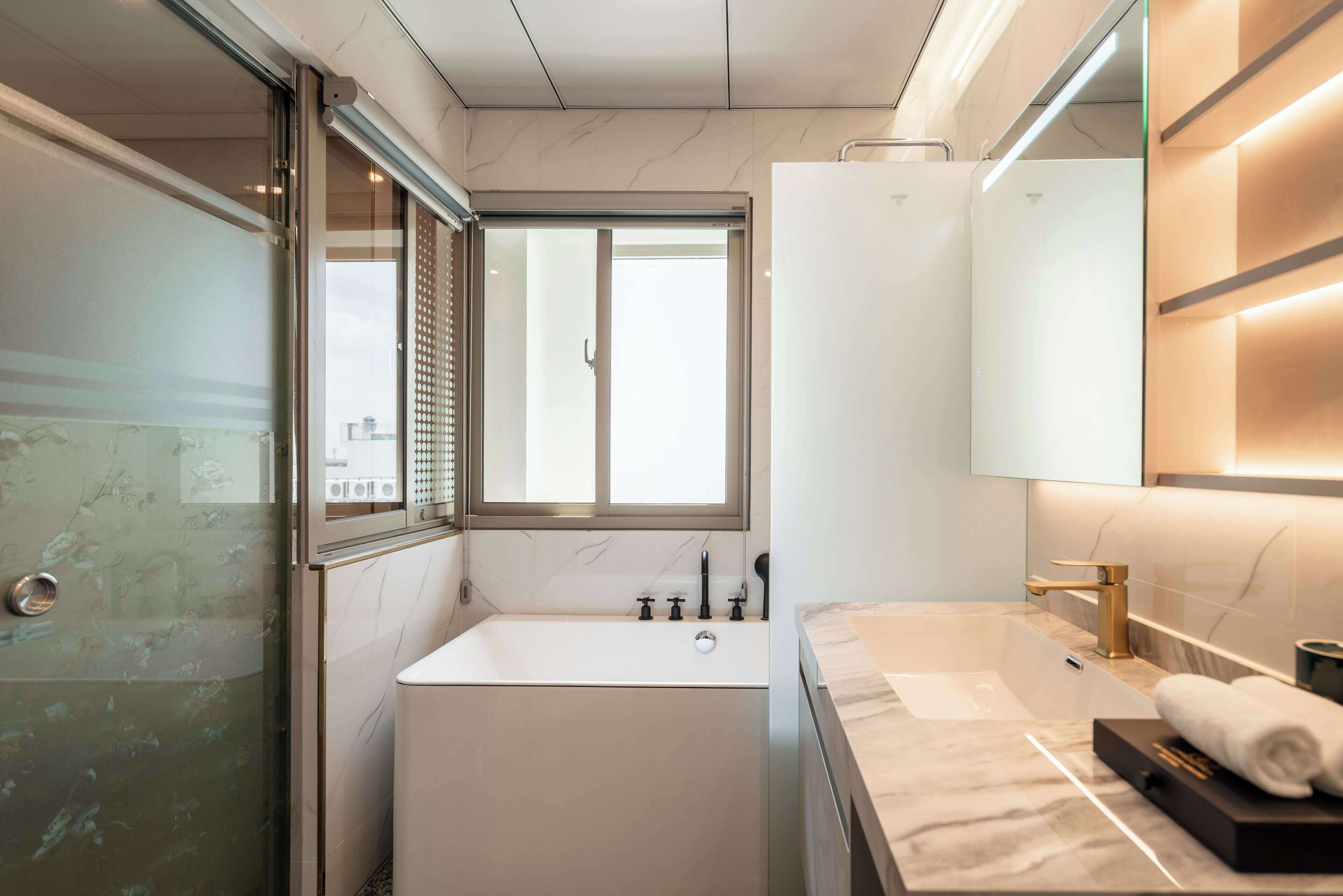 A modern bathroom with a bathtub, a shower, a toilet, and a sink.