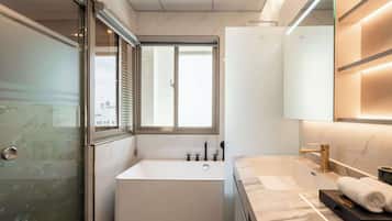 A modern bathroom with a bathtub, a shower, a toilet, and a sink.