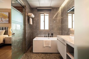 A modern bathroom with a freestanding bathtub, a vanity with a mirror, and a glass shower enclosure.