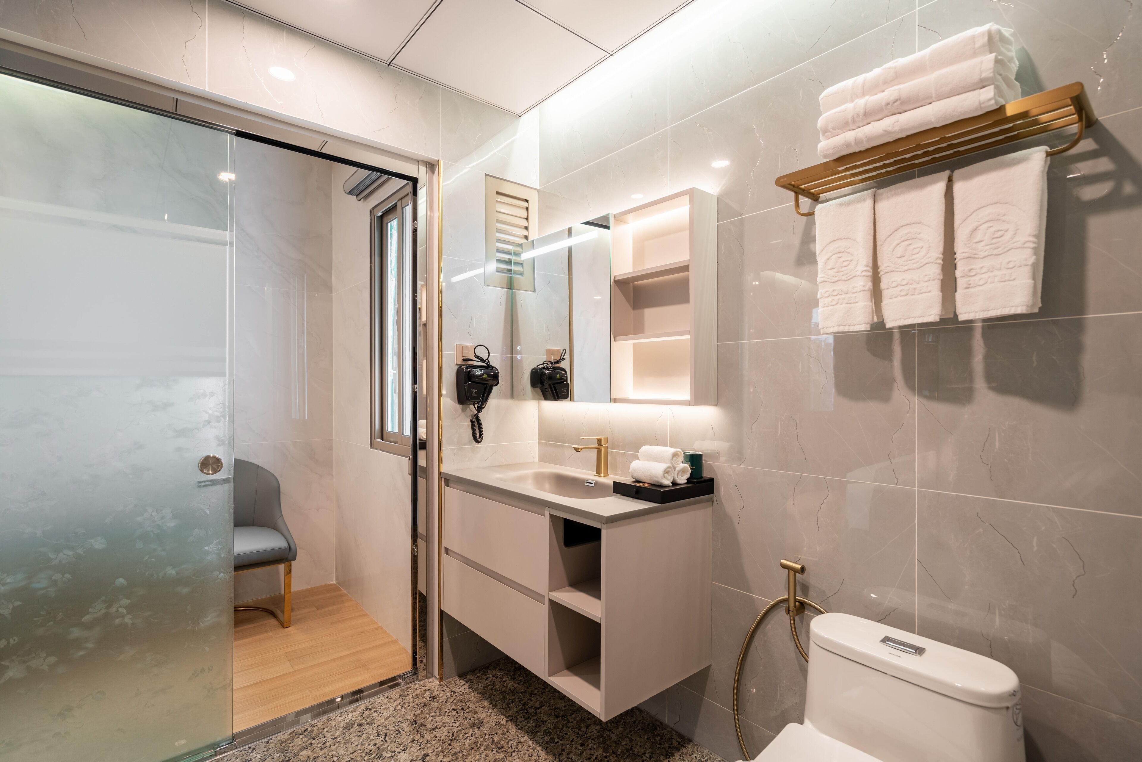 Une salle de bain moderne avec une douche à parois de verre, un meuble-lavabo avec un évier et un miroir, des toilettes et un porte-serviettes.