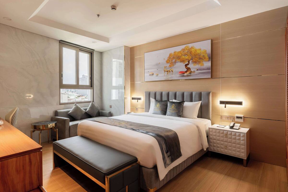 Ein modernes Schlafzimmer mit einem großen Bett, Nachttischen, einer Bank und einem Schreibtisch.